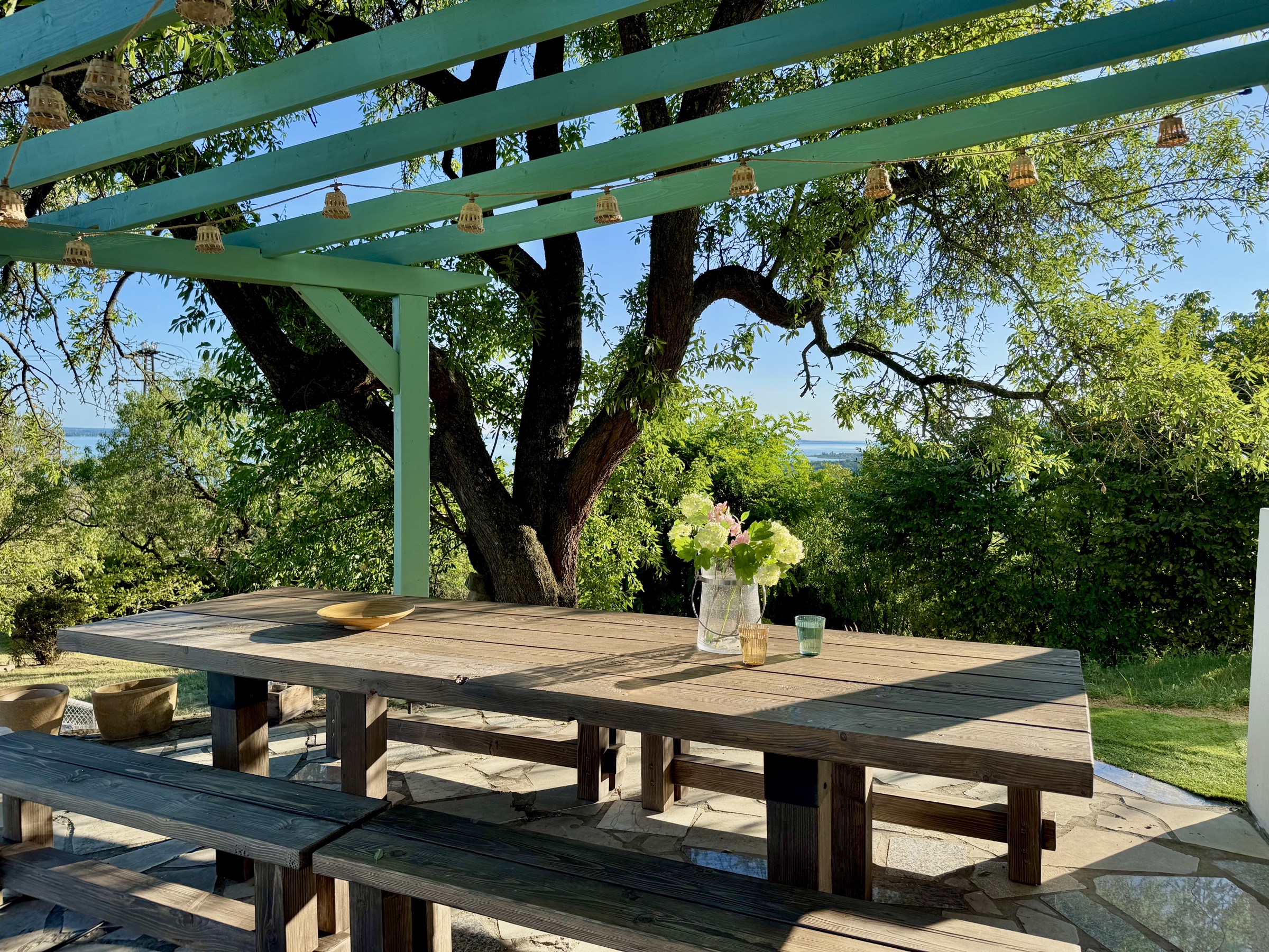 A terasz az íves pergola alatt, a nagy asztallal