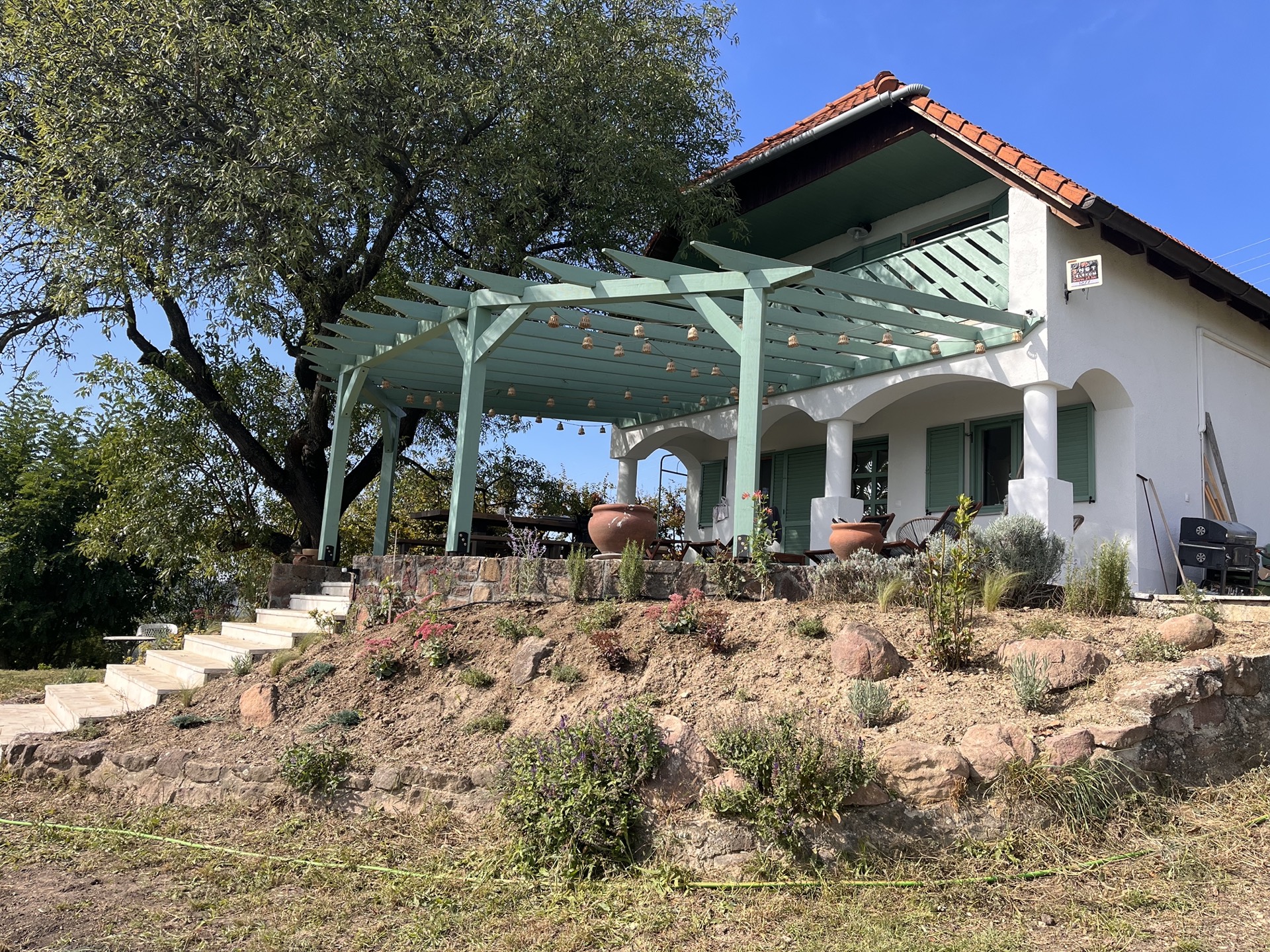 A ház és a pergola nappali fényben
